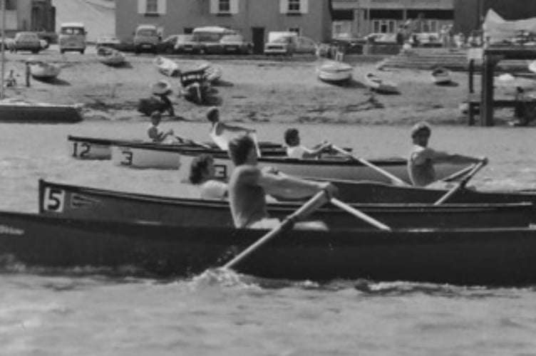 Taking the strain: Competitors row their 15ft skiffs under the road and rail bridges at Saltash during a race from the 1960s