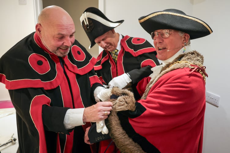 Mayor Cllr Andy Law being helped dress in his robe