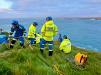 Emergency services rescue injured woman near cliff edge