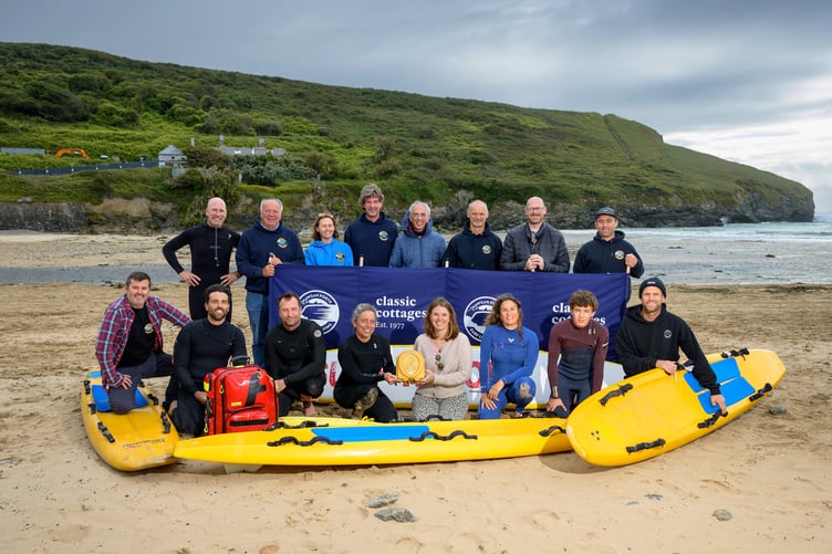 Louise Dale from Classic Cottages (front centre right) presents the training defibrillator to members of the Mawgan Porth Surf Life Saving Club