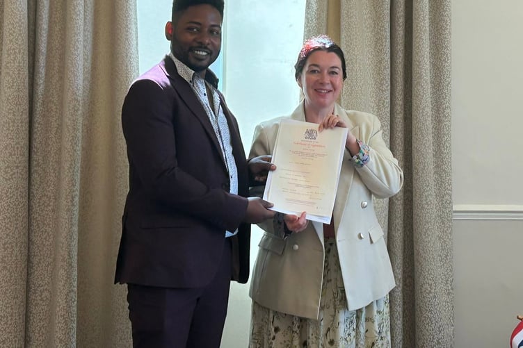 Donte Ragan accepts the certificate stating he is now officially a British citizen from the deputy registrar (Picture: Perran Moon)