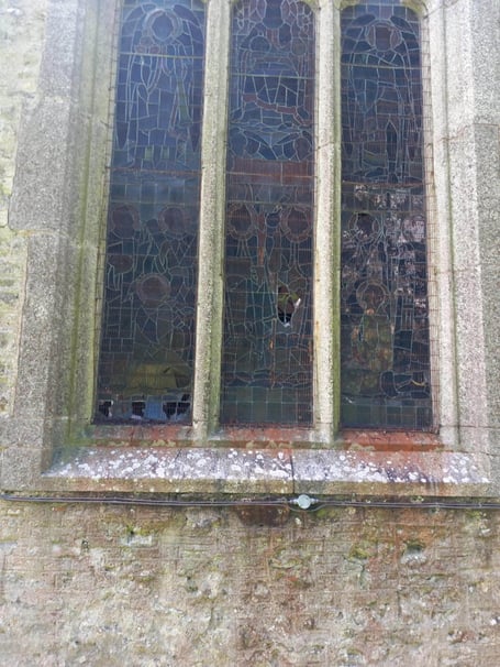 The stained glass window above the altar was broken in what appears to have been an attack from outside