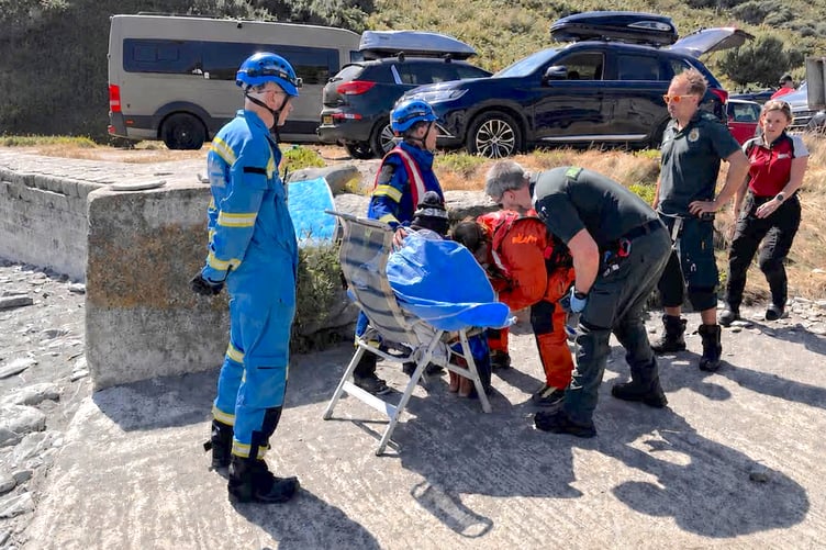 One of the rescued swimmers receiving attention above the beach. (Picture: Mevagissey Coastguards)