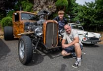 Classic cars on show while live rock and roll plays in Clay Country village