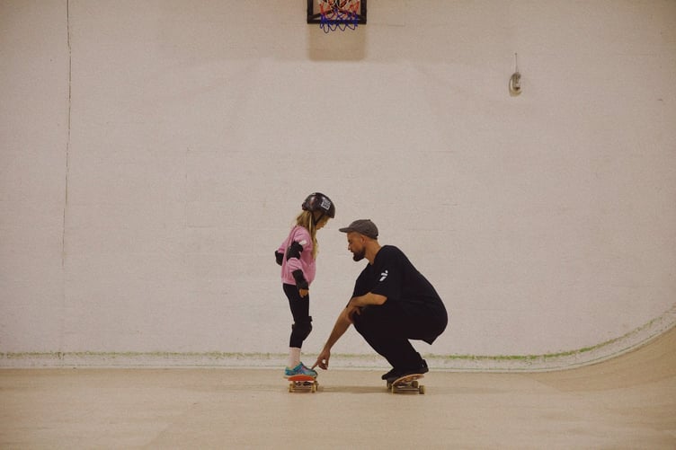 A youngster is given skateboard coaching at TR7 Skatepark at Roche.