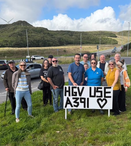 Some of the villagers taking part in the HGV link road protest. Cllr Steve Trevelyan is pictured holding the sign