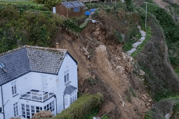 Christopher Bennett's shed hangs off the edge of the cliff while the rockfall narrowly missed Lucia Humphries's property (Picture: SWNS)